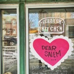 a window with a sign on it that says dear salem.