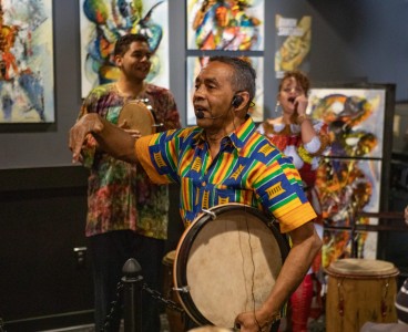 a man holding a drum in front of a group of people.