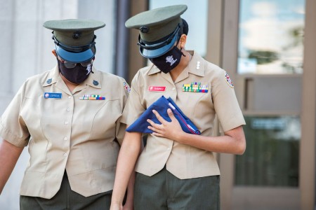 two female police officers in uniform are holding folders.
