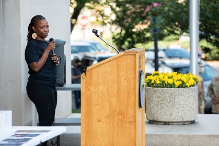a woman standing at a podium giving a speech.