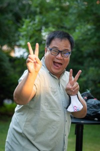 a man with glasses making a peace sign.