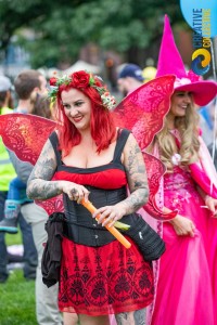 a woman with red hair wearing a costume and holding an umbrella.