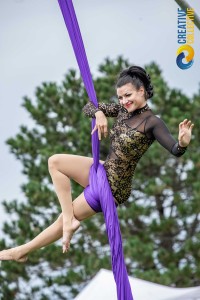 a woman in a leotard doing a trick on a pole.