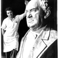 a man standing next to a statue of a man.