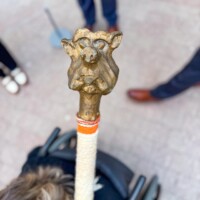 Salem Ma Inauguration 2026 In Essex County, a wheelchair user proudly holds a whimsical cane, surrounded by our lively community on bright tiled pavement.