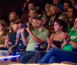 Audience members applaud from their seats at North Shore Music Theatre during A Night for Patrick, many of them wearing green