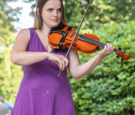 A violinist in a purple dress plays in the gazebo on Beverly Common during Beverly's Garden Party