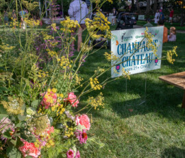 Champagne Chateau sign marked ages 21 and over at Beverly's Garden Party, framed by wildflowers with the Beverly Common gazebo behind it